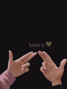 two hands pointing at a green heart with the words love u below them