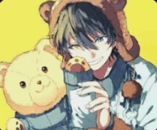 a boy wearing a teddy bear hat is holding a teddy bear in his hands .