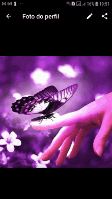 a purple butterfly is sitting on a woman 's finger and the time is 9:51