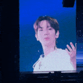 a man is being projected on a large screen at a concert