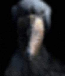 a blurry picture of a person 's face with a black background .