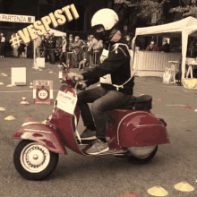 a man riding a red vespa with a sign that says #vespisti