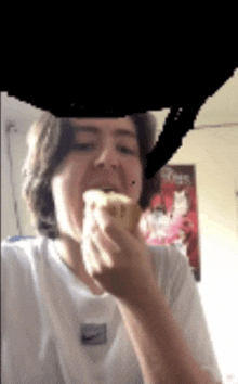 a person wearing a nike shirt is eating a sandwich