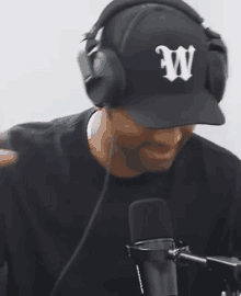 a man wearing headphones and a baseball cap with the letter w on it .