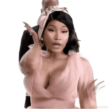 nicki minaj is wearing a pink dress and a headband with a bow .