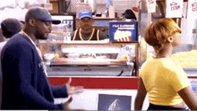 a man standing in front of a popcorn machine that says flat buttered popcorn