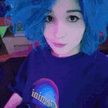 a girl with blue hair is wearing a t-shirt that says inims