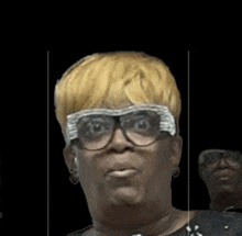 a woman with blonde hair and glasses making a face