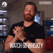 a man clapping with the words watch 68 whiskey written below him