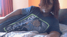 a woman wearing a savage t-shirt is laying on a bed