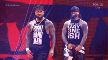 two wrestlers on a stage with one wearing a shirt that says " right hand man "