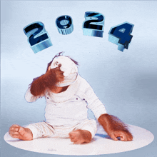 a baby monkey covering his eyes with a bandage and the numbers 2024 are behind him