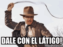 a man in a hat is holding a whip in his hand and saying `` dale con el latigo '' .