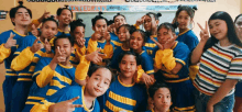 a group of young students are posing for a picture in a classroom .