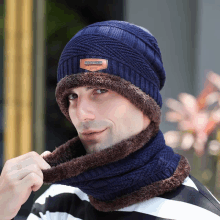 a man wearing a blue beanie and a brown scarf with a badge that says ' stylish ' on it