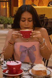 a woman sitting at a table with a cup of coffee