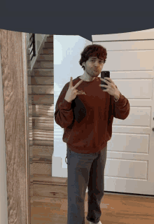 a man taking a picture of himself in front of a mirror with a sweatshirt that says " i love you " on it