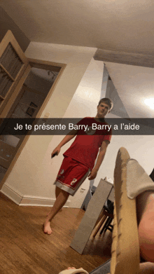 a man in a red shirt and shorts is standing in a room with a caption in french that says je te presente barry