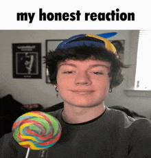 a young man holding a colorful lollipop with the words my honest reaction above him