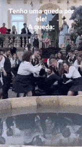 a group of people are standing around a fountain with a caption that says tenho uma queda por ele !