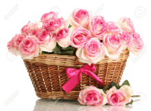 a wicker basket filled with pink and white roses