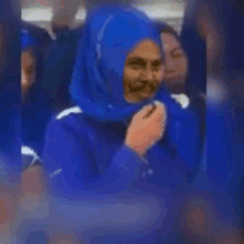 a woman in a blue hijab is sitting on a bus .