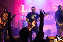 a band playing in front of a sign that says " bad crew "