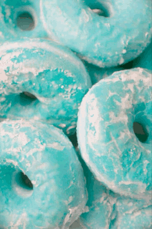 a bunch of blue donuts with white frosting