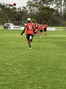 a man wearing a red jersey with the number 41 on it kicks a soccer ball