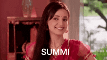 a woman in a red dress is smiling and the word summa is written on the screen .