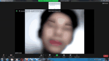 a computer screen shows a blurry picture of a person 's face and the time of 10:13