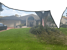 a black car is parked in front of a house with an american flag