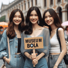 three asian women holding a sign that says museum bola