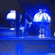 a blurred image of a person standing in front of a table with a blue light behind them .