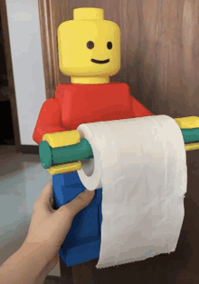 a lego man holds a roll of toilet paper in his hand