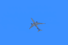 a blue and white airplane is flying in the sky