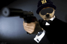 a meerkat wearing a dea hat and goggles is pointing a gun