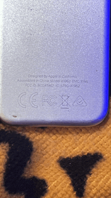 a close up of the back of a phone that says " designed by apple in california "