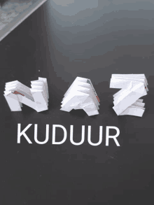 the letters naz and kuduur are made out of paper