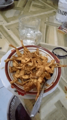 a plate of food sits on a table next to a rendy glass