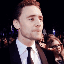a man in a suit and tie is standing in a crowd