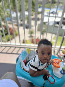 a baby is sitting in a blue walker with a steering wheel