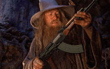 a man with a beard and a hat is holding an ak47