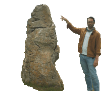 a man pointing at a large rock with his finger