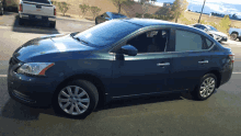 a blue car is parked in a parking lot next to a chevrolet truck