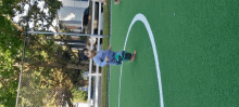 a young boy playing on a soccer field with a white line