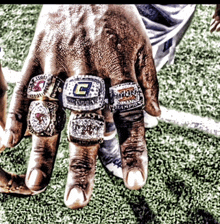 several rings on a person 's hand including one that says ' champions '