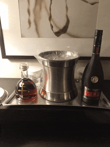 a bottle of remy martin sits on a tray next to a bucket of ice