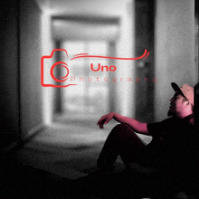 a man leaning against a wall in a hallway with uno photography written above him