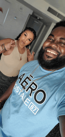 a man wearing a blue aeropostale shirt poses for a photo with a woman